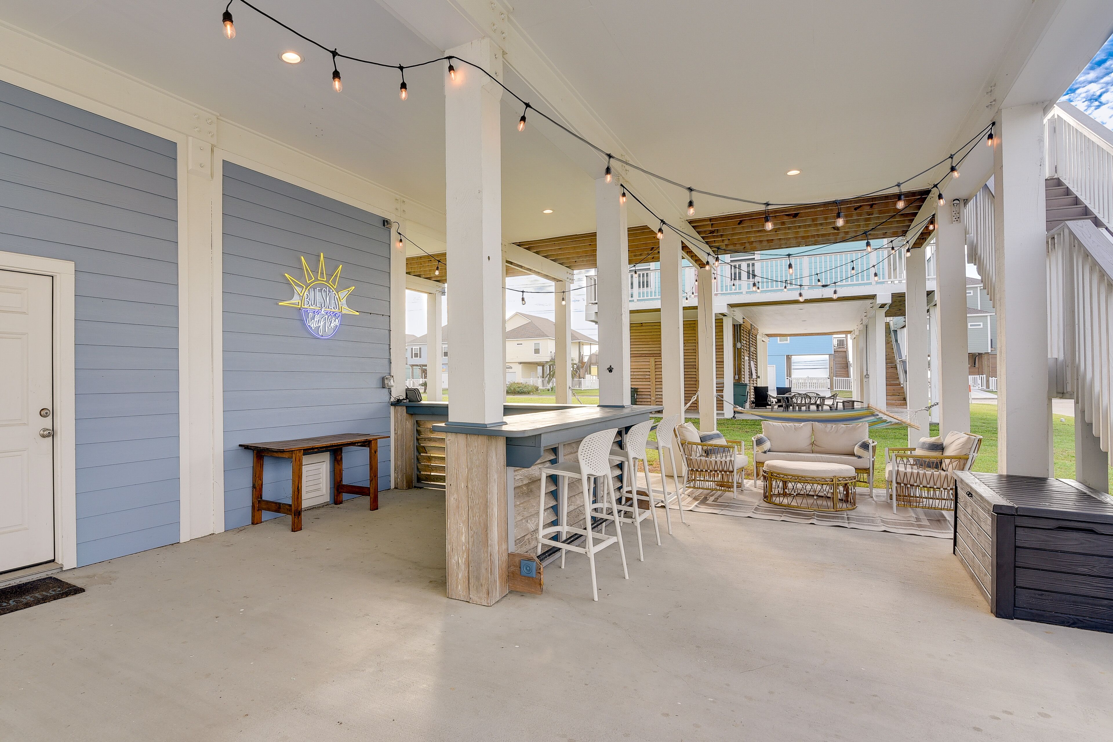 Un espace extérieur aménagé en terrasse, avec un bar, des sièges et une vue sur le quartier.