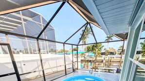 Ein moderner, überdachter Pool mit Glaswänden und Blick auf die Umgebung.