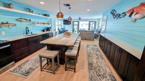 Eine moderne Küche mit blauen Wänden, Holz Arbeitsplatten und Fischdekorationen.
