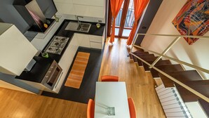 Une cuisine moderne avec un coin repas, un escalier et une vue sur l’extérieur.