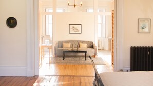 Une pièce avec un plancher en bois, un canapé, une table basse et un radiateur.