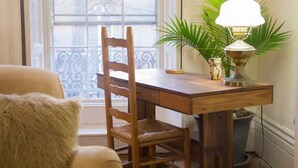 Une table à manger en bois, avec une lampe, une chaise et une plante en pot.