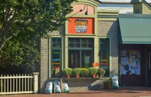 Une boulangerie avec une enseigne indiquant « Boulangerie Rosemont » et une vitrine remplie de produits de boulangerie.