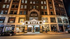 Un edificio con un cartel luminoso que dice "STATE" en la entrada.