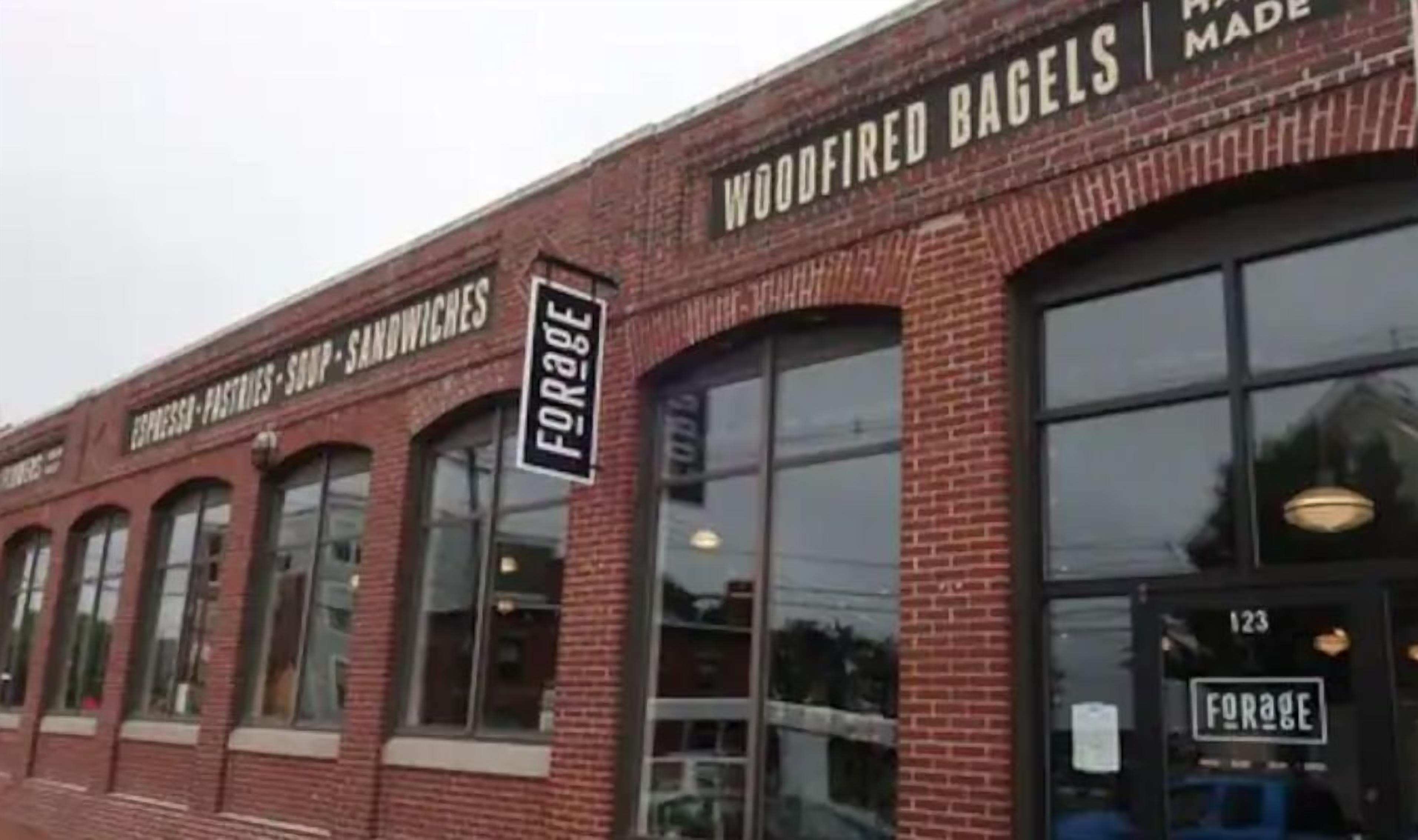 A brick building with a sign for 'Woodfired Bagels' and 'Espresso-Fast Foods - Sandwiches'.