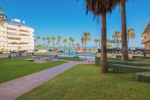 Un resort con piscina, palmeras y vistas al océano.