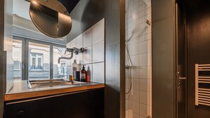 Un baño moderno con ducha, lavamanos y espejo.