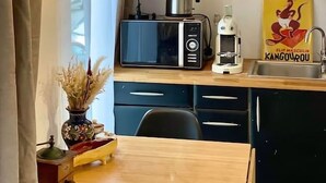 Una cucina compatta con un forno a microonde moderno, una macchina per il caffè e un lampadario.