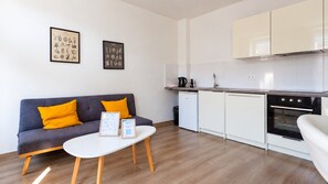 A modern kitchen with white cabinets, a built-in oven, and a coffee maker on the countertop. - Thiergarten·  à 3 minutes à pied de la gare (Strasbourg)
