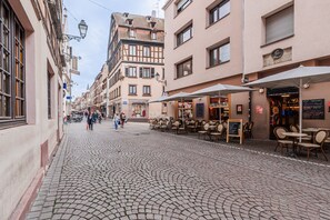 A cobblestone street with outdoor seating, a café, and a restaurant. - Le Cosy Stras - Studio hyper centre (Strasbourg)