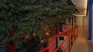 A staircase with red railings, surrounded by lush green foliage and decorative hanging ornaments. - Linda Vecindad Playa del Carmen (Playa del Carmen)