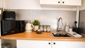 A modern kitchen with a microwave, kettle, sink, and various kitchen items. - Lodge 6 - Lytton Tree Lodge - Reydon (Reydon)