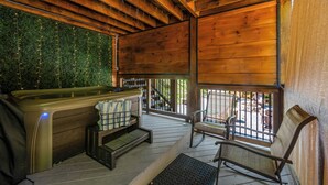 A wooden deck with a hot tub, seating area, and a view of the outdoors. - Ultimate Smoky Getaway: Hot Tub, Fun & Fresh Air in the Heart of the Smokies. (Sevierville)