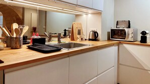 A modern kitchen with a stainless steel sink, a toaster, and a kettle. - Le Bijou du Minage - Jardin/terrasse - Hypercentre LA Rochelle (La Rochelle)