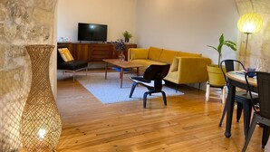 Una sala de estar acogedora con sofá, mesa de centro y televisor.