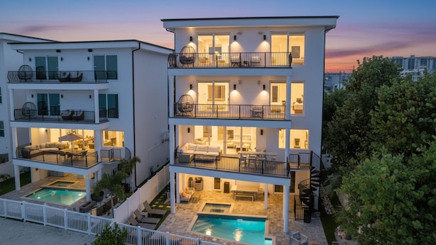 A multi-story residential building with a pool, balconies, and outdoor seating areas. - Beach One: Style Meets the Shore w/ Pool and Spa (Treasure Island)