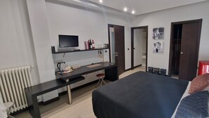 A modern hotel room with a bed, a desk, a TV, and a wardrobe. - Thalassa Bari (Bari)