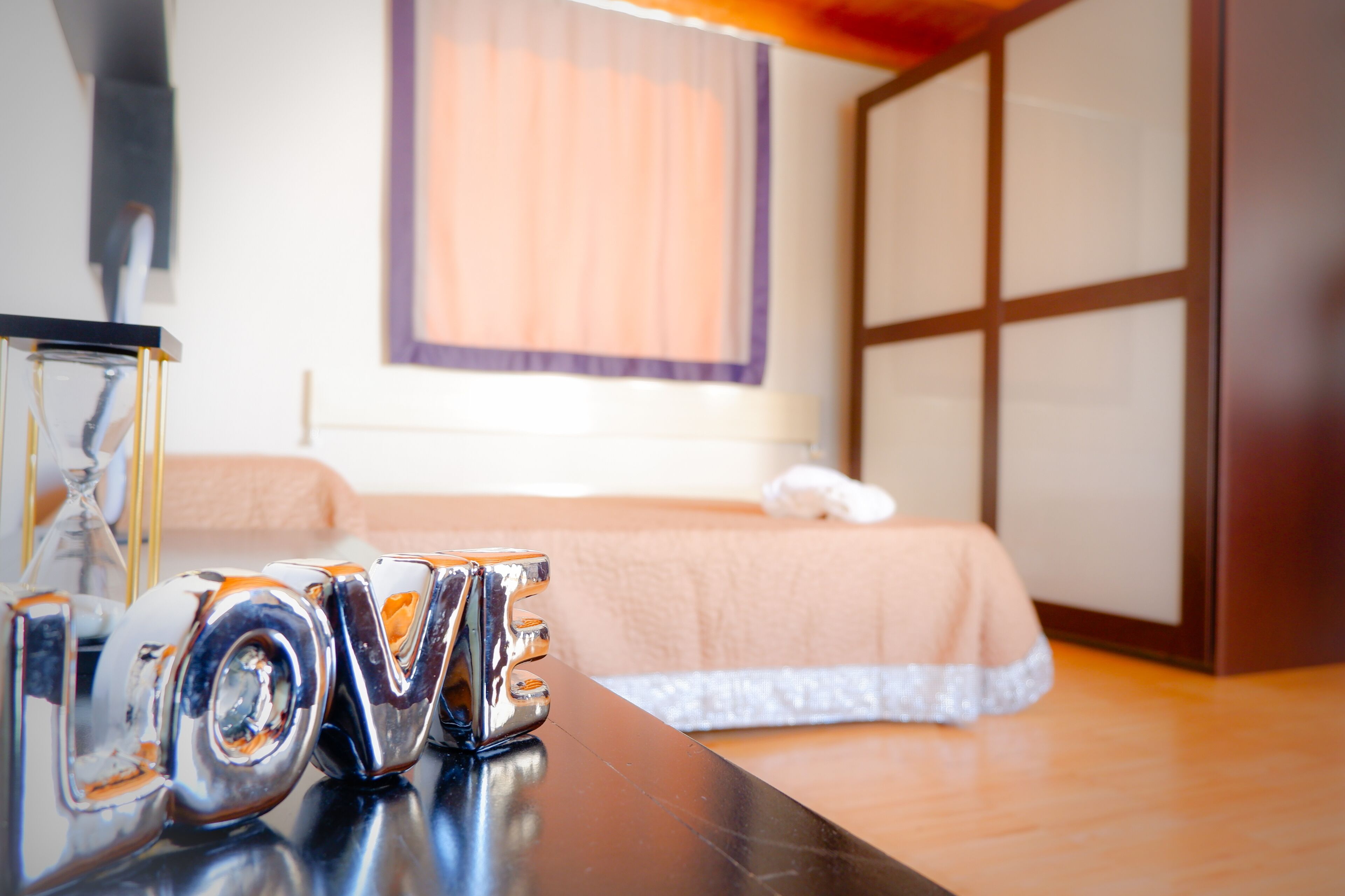 A hotel room with a bed, a dresser, and a vanity with a mirror.