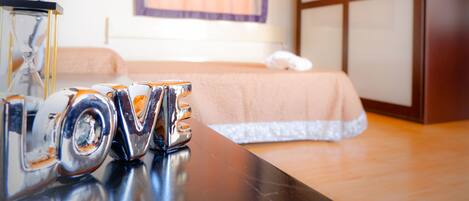 A hotel room with a bed, a dresser, and a vanity with a mirror.