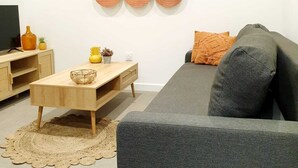 A modern living room with a grey sofa, wooden coffee table, and a wall-mounted circular decoration. - The bohemian (Pamiers)