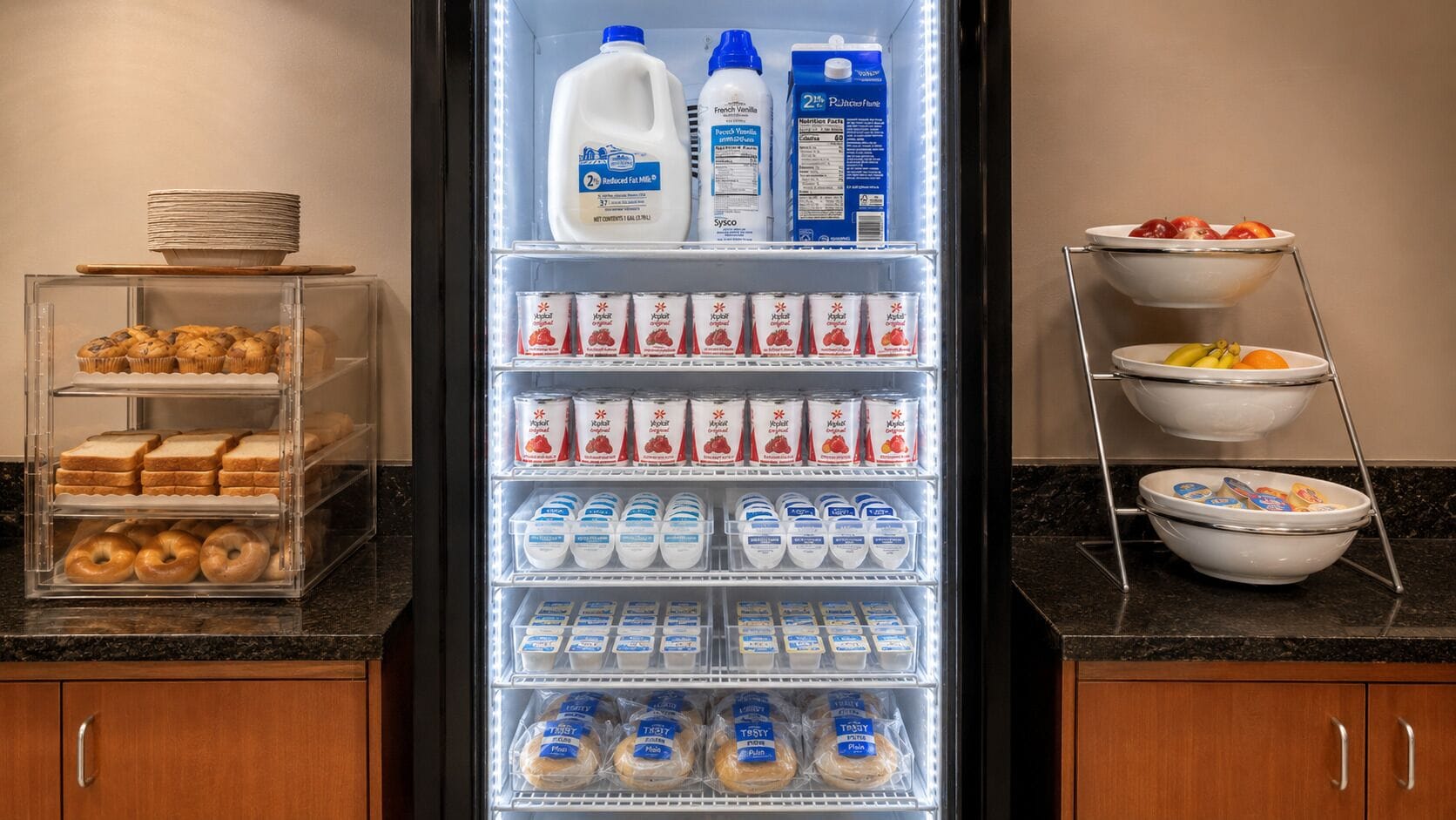 Un réfrigérateur rempli de divers aliments, notamment du lait, des yaourts et du pain.