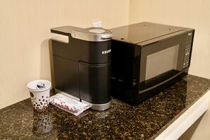 A coffee maker and microwave on a granite countertop. - The Boston Hotel (Boston)
