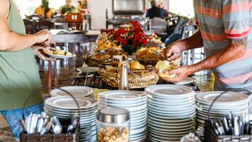 A buffet setup with various food items and stacked plates.