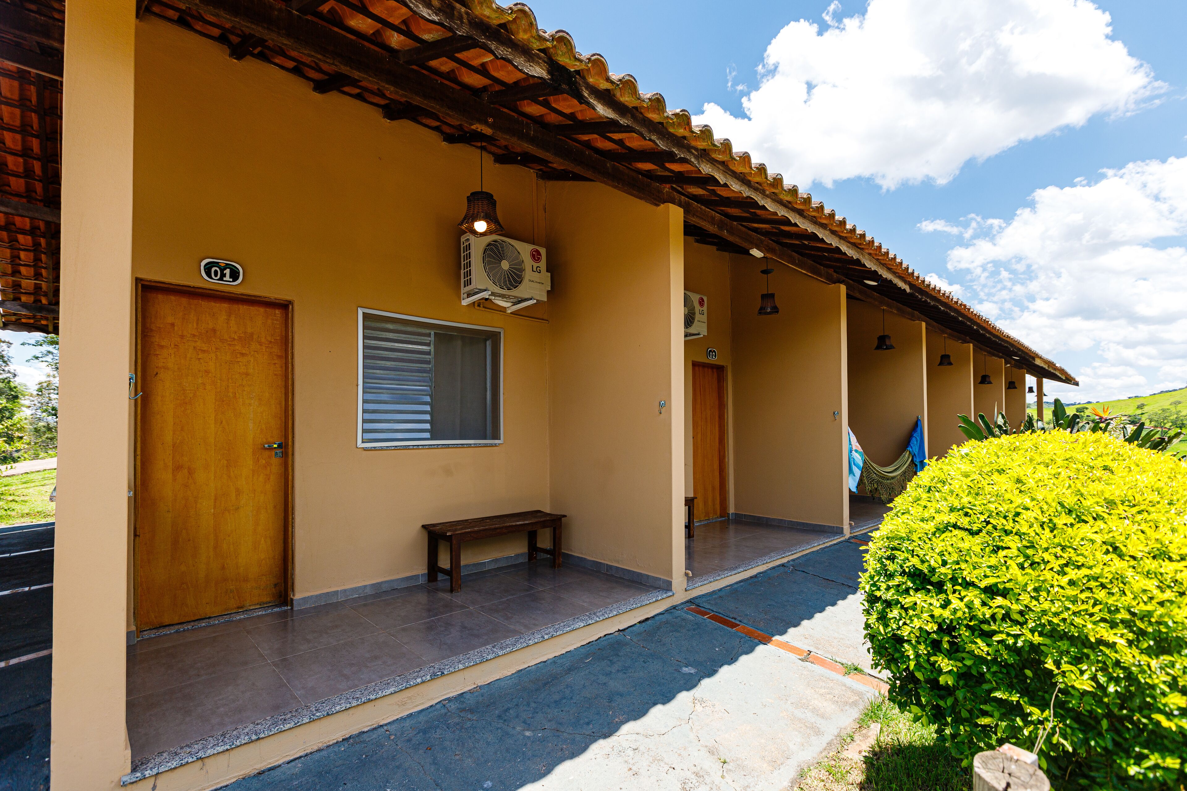 A building with a tiled floor, a wooden bench, and a door marked with the number 01.