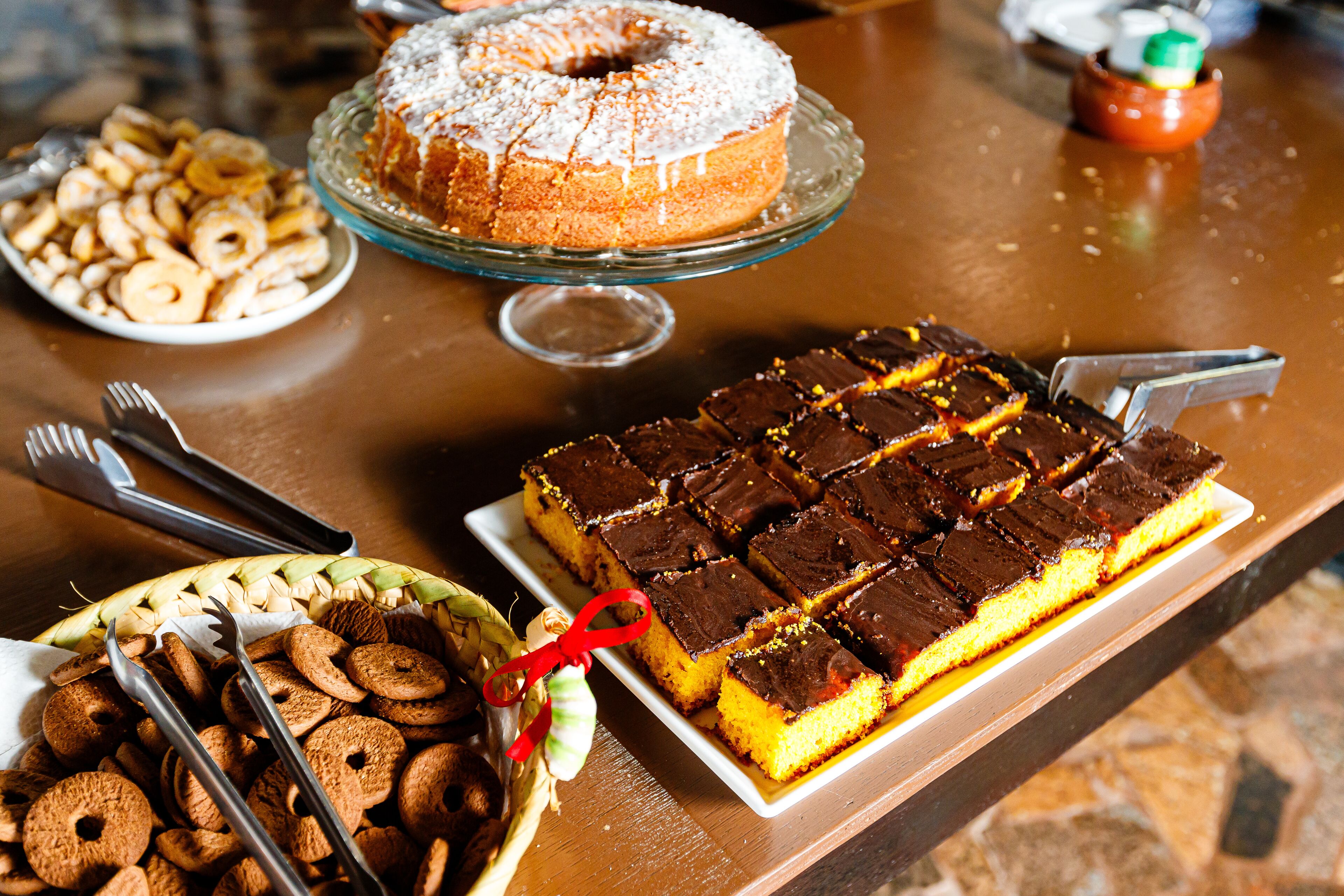 A buffet table with various desserts including a bundt cake, brownies, and cookies.
