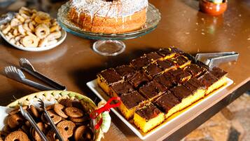 A buffet table with various desserts including a bundt cake, brownies, and cookies.