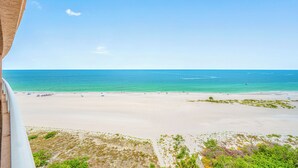 A beach view from a balcony with a clear sky, sandy beach, and ocean. - 🌞CBC 2-11B | Gulf-view 2BR/2BA condo on Clearwater Beach with pool & tennis! (Clearwater Beach)