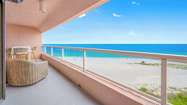 A balcony with wicker furniture, a view of the beach, and a clear sky. - 🌞CBC 2-11B | Gulf-view 2BR/2BA condo on Clearwater Beach with pool & tennis! (Clearwater Beach)
