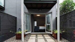 Una casa moderna con un vialetto in pietra che conduce a una camera da letto con un letto e una finestra.