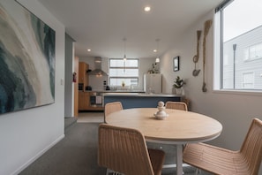 Enjoy meals in the spacious kitchen with a large island and dining area, featuring a round table and four chairs.