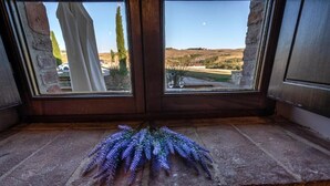 A stone ledge with a view of a rural landscape through a window.