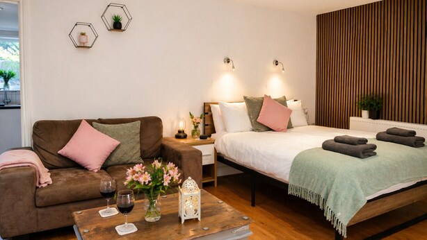 A modern bedroom with a bed, bedside tables, a sofa, and a coffee table.