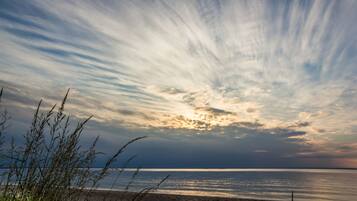 Rannalla, aurinkotuoleja, rantapyyhkeitÀ