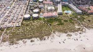 An aerial view of a coastal resort with multiple buildings, parking lots, and a beach area. - ~Hot Tub~2 King Beds~3 Bedrooms~Walk to Beach, Free Parking, Close to Downtown (St. Augustine)