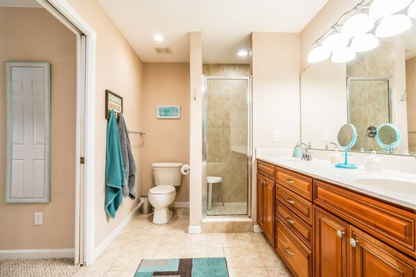 A bathroom with a shower, toilet, and vanity with a mirror. - ~Hot Tub~2 King Beds~3 Bedrooms~Walk to Beach, Free Parking, Close to Downtown (St. Augustine)