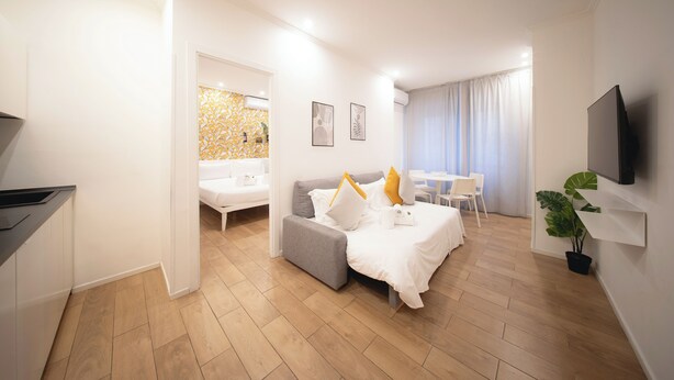 A modern hotel room with a bed, a sofa, a dining area, and a TV. - IV HOUSE 
Luxurious apartment in Rome (Roma)