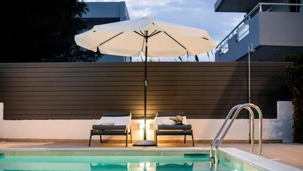 A swimming pool with two lounge chairs and an umbrella. - Angels Villa in Kremasti Near the Beach (Rhodes)