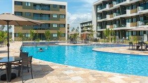 Un hôtel doté d’une piscine, d’un espace extérieur aménagé et de plusieurs balcons.