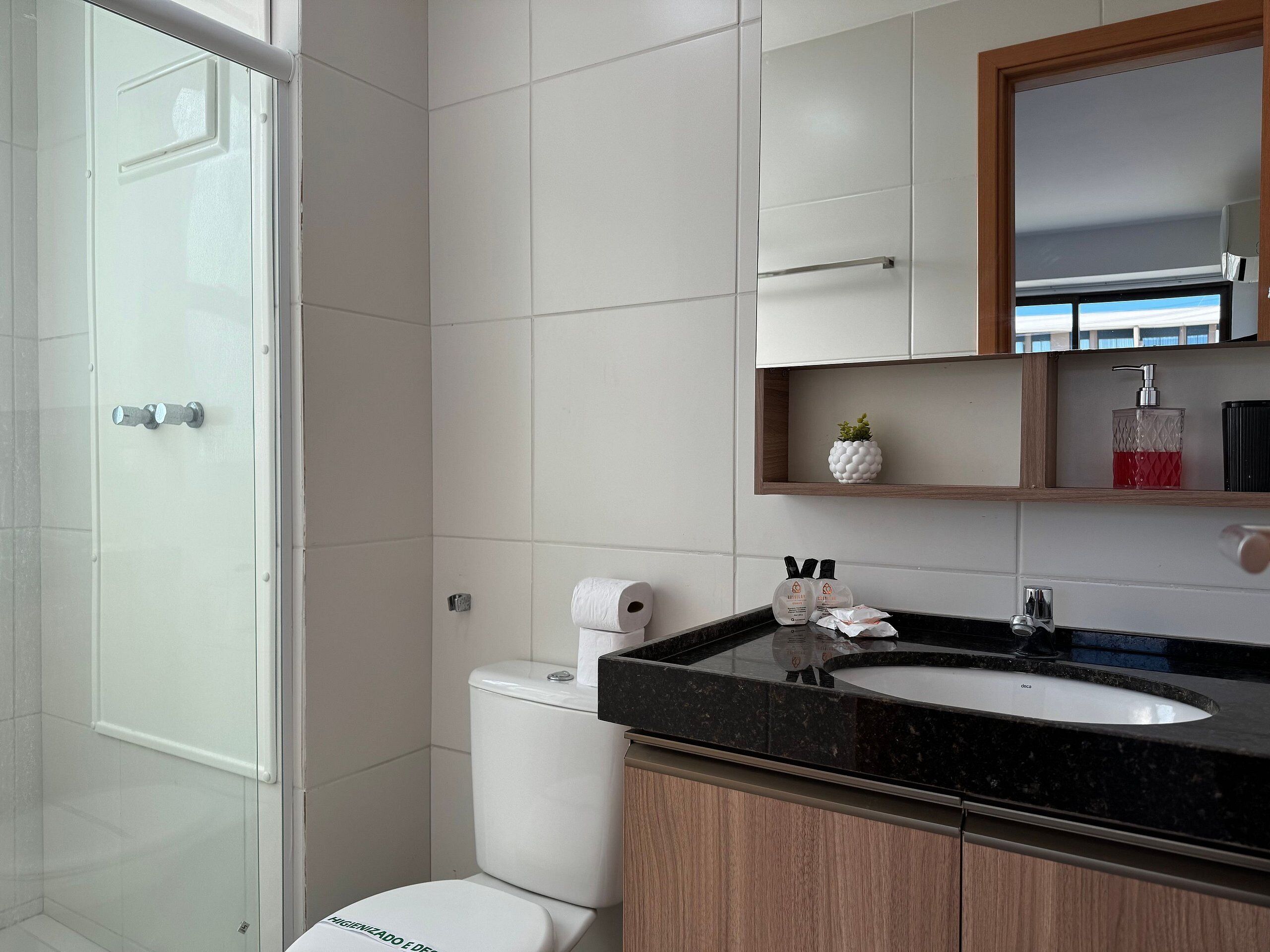 A modern bathroom with a toilet, sink, and shower.