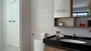 A modern bathroom with a toilet, sink, and shower.