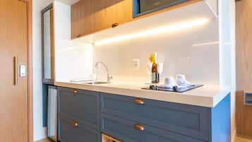 Una cocina moderna con microondas integrado, un fregadero y una botella de vino en la encimera.