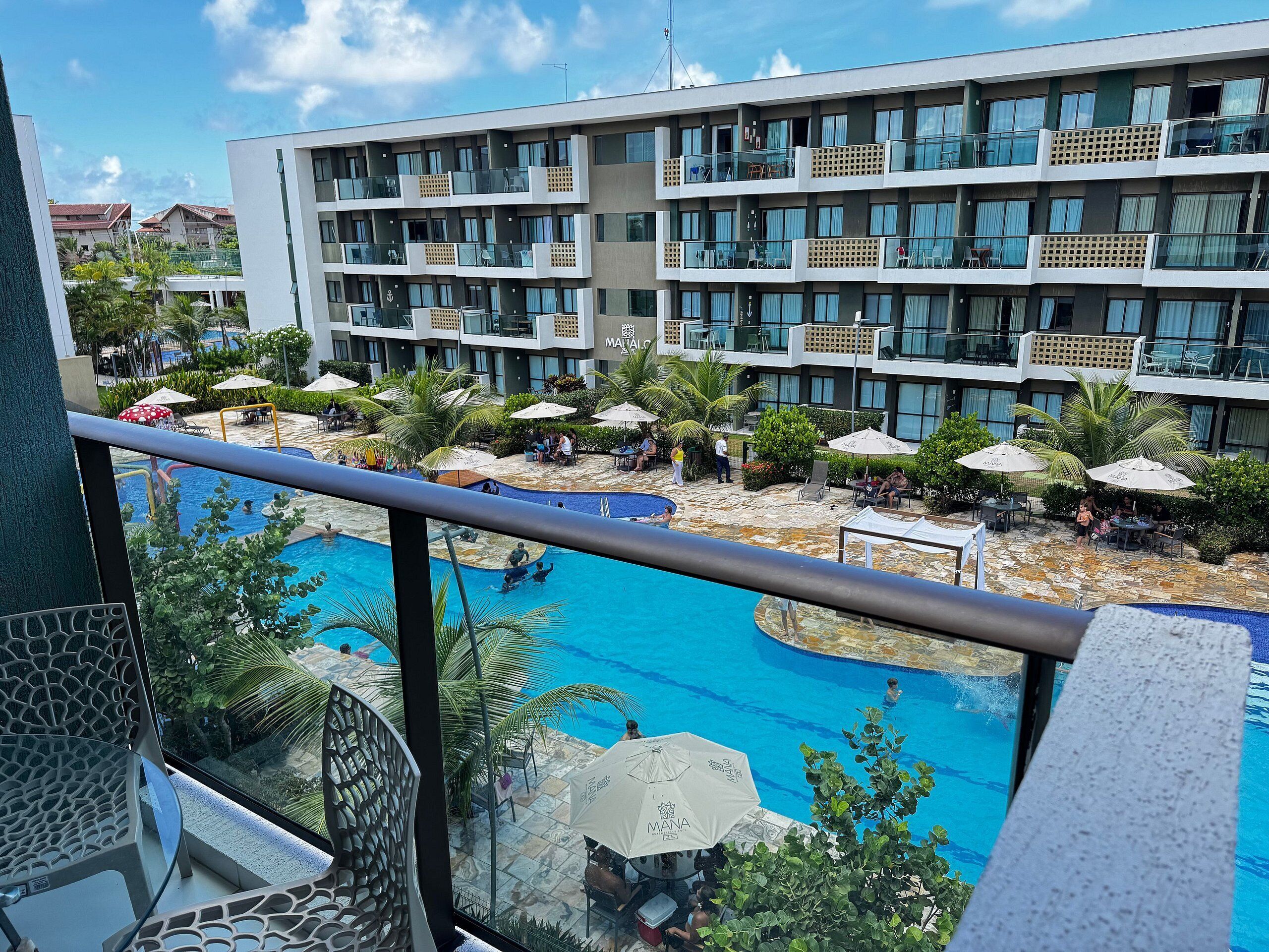 Un hotel con piscina, zona de estar al aire libre y vistas de los edificios circundantes.