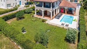 Una villa con piscina, arquitectura de piedra y un jardín bien cuidado.