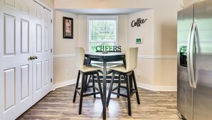 A kitchen with a dining table, chairs, a refrigerator, and a window with blinds. - Central High Point Home < 1 Mi to Downtown! (High Point)