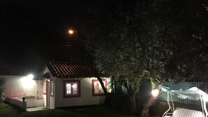 A small house with a tiled roof and a porch, surrounded by grass and trees. - Lisbon Cozy House w/Garden and Pool (Barcarena)