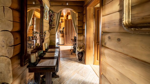 Un intérieur en bois avec une longue table, des chaises et un miroir.